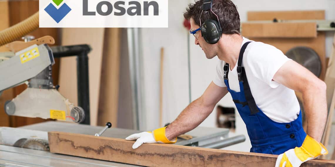 worker in a carpenter's workshop using saw machine